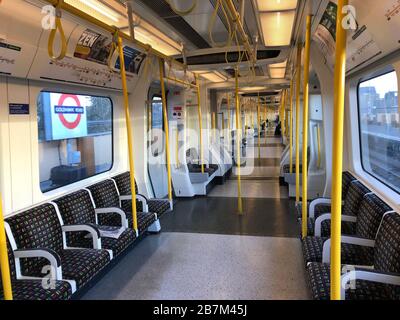 Eine spärlich besetzte Kutsche in einem U-Bahn-Zug im Westen Londons am Tag, nachdem Premierminister Boris Johnson die Menschen dazu aufforderte, sich von Kneipen, Clubs und Theatern fernzuhalten, möglichst von zu Hause aus zu arbeiten und alle nicht notwendigen Kontakte zu vermeiden und zu reisen, um die Auswirkungen der Coronavirus Pandemie zu verringern. Stockfoto