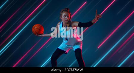 Kreativer Sport und Neonlinien auf dunklem Hintergrund, Flyer, Angebot. Basketballspielerinnen trainieren in Action und Bewegung. Konzept von Hobby, gesundem Lebensstil, Jugend, Action, Bewegung, modernem Stil. Stockfoto