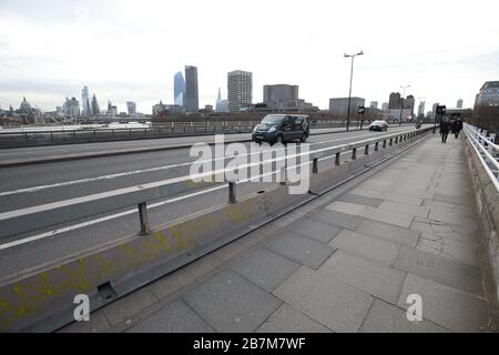 Ein Pendler überquert in London eine leere Waterloo-Brücke, am Tag nachdem Premierminister Boris Johnson die Menschen dazu aufforderte, sich von Kneipen, Clubs und Theatern fernzuhalten, möglichst von zu Hause aus zu arbeiten und alle nicht notwendigen Kontakte zu vermeiden und zu reisen, um die Auswirkungen der Coronavirus Pandemie zu verringern. Stockfoto