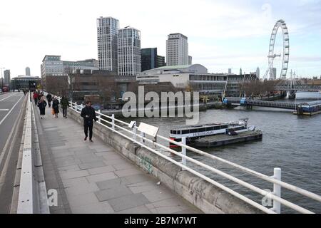 Ein Pendler überquert in London eine leere Waterloo-Brücke, am Tag nachdem Premierminister Boris Johnson die Menschen dazu aufforderte, sich von Kneipen, Clubs und Theatern fernzuhalten, möglichst von zu Hause aus zu arbeiten und alle nicht notwendigen Kontakte zu vermeiden und zu reisen, um die Auswirkungen der Coronavirus Pandemie zu verringern. Stockfoto