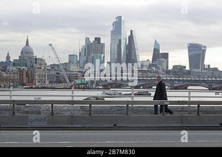 Ein Pendler überquert in London eine leere Waterloo-Brücke, am Tag nachdem Premierminister Boris Johnson die Menschen dazu aufforderte, sich von Kneipen, Clubs und Theatern fernzuhalten, möglichst von zu Hause aus zu arbeiten und alle nicht notwendigen Kontakte zu vermeiden und zu reisen, um die Auswirkungen der Coronavirus Pandemie zu verringern. Stockfoto