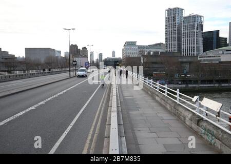 Ein Pendler überquert in London eine leere Waterloo-Brücke, am Tag nachdem Premierminister Boris Johnson die Menschen dazu aufforderte, sich von Kneipen, Clubs und Theatern fernzuhalten, möglichst von zu Hause aus zu arbeiten und alle nicht notwendigen Kontakte zu vermeiden und zu reisen, um die Auswirkungen der Coronavirus Pandemie zu verringern. Stockfoto