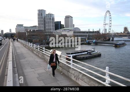 Ein Pendler überquert in London eine leere Waterloo-Brücke, am Tag nachdem Premierminister Boris Johnson die Menschen dazu aufforderte, sich von Kneipen, Clubs und Theatern fernzuhalten, möglichst von zu Hause aus zu arbeiten und alle nicht notwendigen Kontakte zu vermeiden und zu reisen, um die Auswirkungen der Coronavirus Pandemie zu verringern. Stockfoto