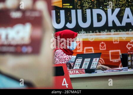 März 2020, Makassar, South Sulawesi, Indonesien: Weibliche Mitarbeiter eines der Mobilfunkanbieter Indonesiens tragen Masken, während sie sich an einem Handystand in Makassar City, Provinz South Sulawesi, Indonesien befinden. Mobilfunkanbieter bereiten zusätzliche Dienste vor und garantieren Internetnetzwerke für Studenten, die zu Hause online arbeiten und studieren können. Das Online-Lernen mit dem Online-System wurde von der indonesischen Regierung angewiesen, die Ausbreitung von Coronavirus zu verringern (Kreditbild: © Herwin Bahar/ZUMA Wire) Stockfoto