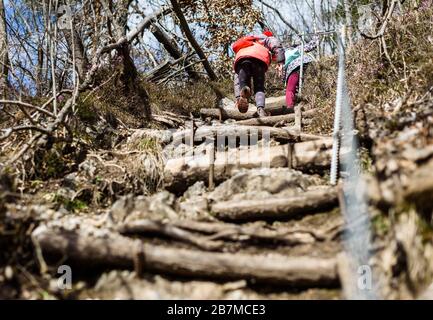 Kinder, die auf Familienausflug in die Berge oder in den Wald wandern. Aktive Familie, Eltern und Kinder Bergsteigen in der Natur. Kinder gehen im Wald Stockfoto