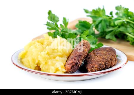 Fleischbällchen mit Kartoffelpüree und Petersilie auf weißem Grund Stockfoto