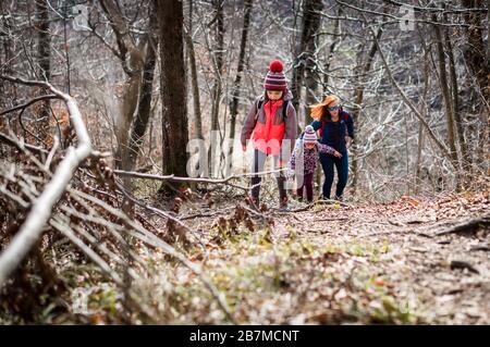 Familienporträt auf Waldreise mit Wanderkleidung. Winterporträt der Familie auf Familienwanderung in Wald, aktive Familie, Eltern und Kinder Stockfoto