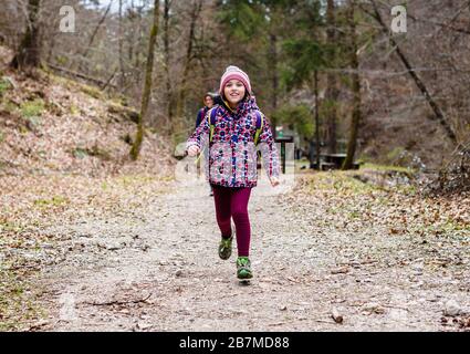 Kinder, die auf Familienausflug in die Berge oder in den Wald wandern. Aktive Familie, Eltern und Kinder Bergsteigen in der Natur. Kinder gehen im Wald Stockfoto