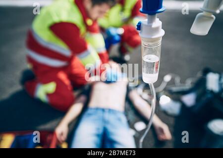 Herz-Lungen-Wiederbelebung. Rettungsteam (Arzt und Sanitäter) reanimittierender Mann auf der Straße. Themen helfen, hoffen auf eine Gesundheitsversorgung. Stockfoto