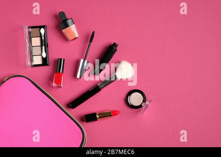 Kosmetiktasche mit Kosmetikartikeln und professionellen Make-Up-Künstler-Tools auf pinkfarbenem Hintergrund. Flache Lage, Draufsicht. Schönheits- und Modekonzept. Stockfoto