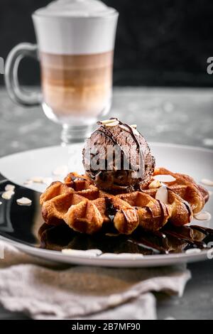 Wiener Waffeln mit Eis und Kaffee. Wunderschönes Dessertbild mit Lettenkaffee. Dessertkonzept, süßes Leben. Lebensmittelfoto, Kopierbereich, grau Stockfoto