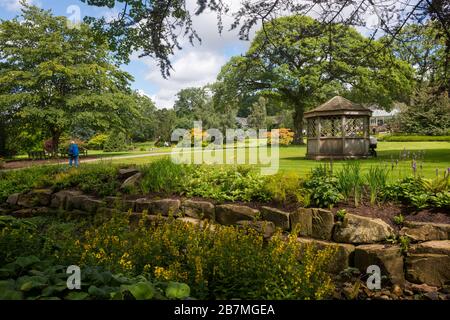 Ein Holzsommerhaus zwischen den Rasenflächen und grenzt an den RHS-Garten in Harlow Carr bei Harrogate, North Yorkshire Stockfoto