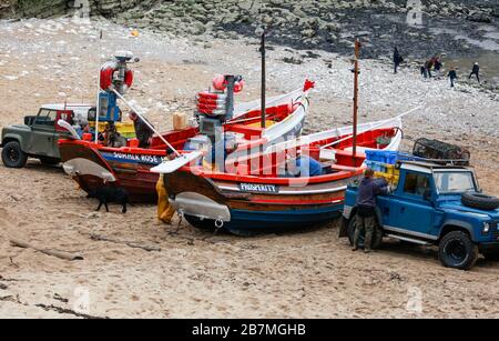 Ein Paar der traditionellen offenen Fischerboote aus Yorkshire mit Kopfsteinpflaster, die für den Tag bei der Landung in Flamborough North an der Küste von Yorkshire vorbereitet werden Stockfoto