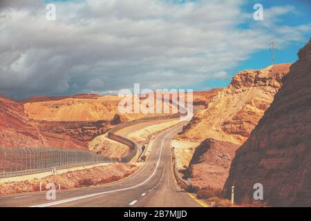 Fahren eines Autos auf der israelischen Bergstraße. Wüstenlandschaft. Leere Straße. Die Straße verläuft entlang der Grenze Israels zu Ägypten. Blick vom Auto der mou Stockfoto