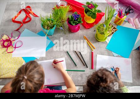 Zwei Mädchen malen Farbbilder am Tisch. Stockfoto