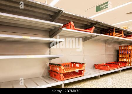 Leere Regale in einem britischen Supermarkt, in dem Käufer wegen der Coronavirus-Pandemie in Panik Brot kauften. Stockfoto