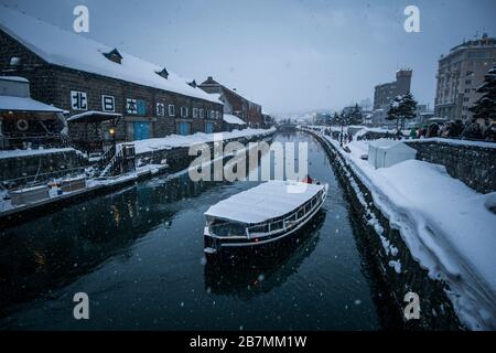 Ein Winterblick auf ein Sightseeing-Boot auf dem berühmten Kanal in Otaru, Hokkaido, Japan. Stockfoto