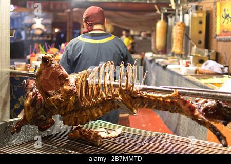 Kadaver oder Skelett von Schwein oder Ferkel und Brocken, die auf dem lokalen Fleischmarkt hängen, nachdem sie fertig gekocht wurden, um serviert zu werden Stockfoto