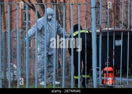 Ein Feuerwehrmann desinfiziert bei den Sanitätskontrollmaßnahmen einen in einen Schutzanzug gekleideten Mann an der deutsch-polnischen Grenze bei der Stadtbrücke von Goerlitz und Zgorzelec. Stockfoto