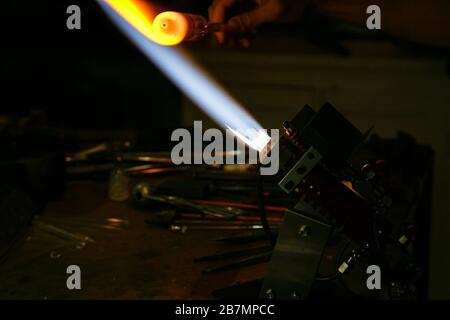 Verarbeitung Glasbläserherstellung . Feuer erhitzt Glasrohling mit Glasbläserbrenner. Handgefertigte Glashütten Stockfoto