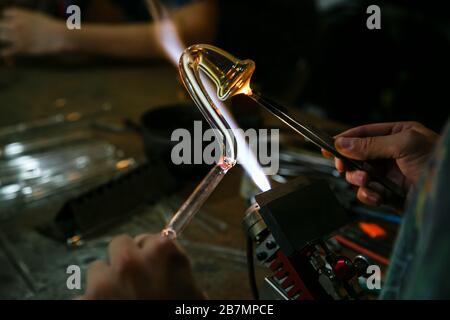 Verarbeitung Glasbläserherstellung . Feuer erhitzt Glasrohling mit Glasbläserbrenner. Handgefertigte Glashütten Stockfoto