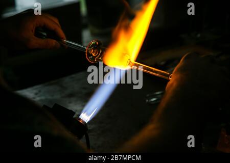 Verarbeitung Glasbläserherstellung . Feuer erhitzt Glasrohling mit Glasbläserbrenner. Handgefertigte Glashütten Stockfoto