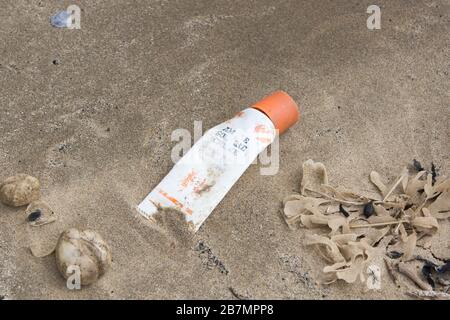 Ein Plastikschlauch aus Ambre Solaire, Sonnenbräunung, ist am Harlech Strand in Westwales UK als Müll hinterlassen worden, ein Beispiel für die vielen Plastikteile im Meer Stockfoto