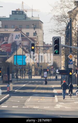 Laibach, Slowenien - 17. März 2020: Arbeitsscheinwerfer in der Innenstadt von Laibach, Slowenien auf fast leeren Straßen mit wenigen Fahrrädern und Pedes Stockfoto