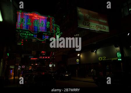 Nachtneon-Zeichen in Hongkong in Dunkelheit Stockfoto