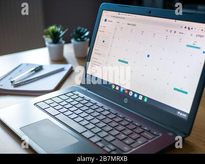 März 2020 Großbritannien: Organisierter Kalender Laptop chromebook Arbeiten zu Hause mit Notizblock Stockfoto