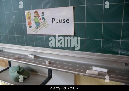 Leeres Klassenzimmer, auf der Tafel steht ein Schild mit dem Wort PAUSE, Kreide liegt auf dem Regal, Schulen und Kindertagesstätten werden wegen der sich ausbreitenden Coronavirus-Pandemie geschlossen. Hinweis, Hinweis an der Haustür der Gemeinschaftsschule an der Heinrich Strunk-Straße in Essen, 16. März 2020. Weltweite Verwendung Stockfoto