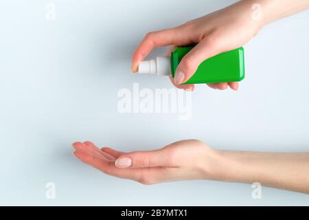 Desinfektionsmittelpumpenflasche in weiblichen Händen. Frau, die antibakterielles Spray anwendet. Vorbeugung gegen Coronavirus Disease (Covid-19) und Schutz der Gesundheit während der Grippe Stockfoto
