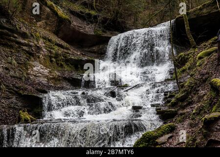 Kleiner Wasserfall im Canyon inmitten des grünen Waldes Stockfoto