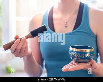 Haulerwijk - 07. märz 2020: Haulerwijk, Niederlande. Nahaufnahme der indischen Gesangsschüssel in der Hand der Frau. Meditations- und Entspannungskonzept Stockfoto