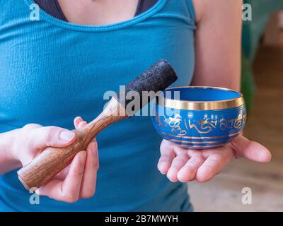 Haulerwijk - 07. märz 2020: Haulerwijk, Niederlande. Nahaufnahme der indischen Gesangsschüssel in der Hand der Frau. Meditations- und Entspannungskonzept Stockfoto