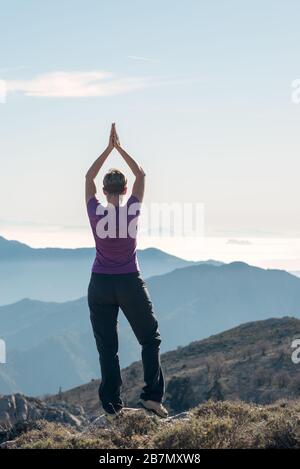 Wanderer, die Yoga auf dem Berg machen. Stockfoto