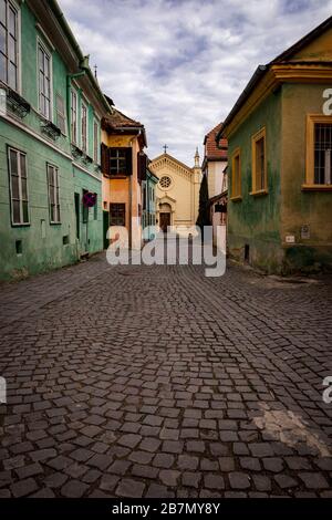 SIGHISOARA, RUMÄNIEN, 13. März 2020. Obwohl es außerhalb der Tourismussaison ist, gibt es immer noch sehr wenige Menschen auf den Straßen der Zitadelle Sighisoara mit COVID-19 Beeinflussung der Entscheidung der Völker, nicht zu besuchen. Das sächsische Gebäude aus dem 12. Jahrhundert gehört zum UNESCO-Weltkulturerbe und soll angeblich der Ort sein, an dem Vlad 'The Impaler' Tepes (AKA Dracula) geboren wurde. In der Ferne befindet sich die Römisch-Katholische Kirche der Zitadelle. Foto © Matthew Lofthouse - Freelance Fotograf Stockfoto