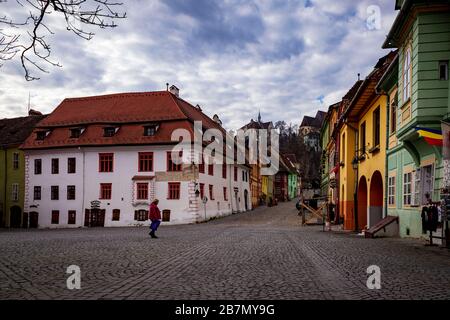 SIGHISOARA, RUMÄNIEN, 13. März 2020. Obwohl es außerhalb der Tourismussaison ist, gibt es immer noch sehr wenige Menschen auf den Straßen der Zitadelle Sighisoara mit COVID-19 Beeinflussung der Entscheidung der Völker, nicht zu besuchen. Das sächsische Gebäude aus dem 12. Jahrhundert gehört zum UNESCO-Weltkulturerbe und soll angeblich der Ort sein, an dem Vlad 'The Impaler' Tepes (AKA Dracula) geboren wurde. Hier ist der Zitadellenplatz Piata Cetatii, leer, ohne Leute, Tische oder Stühle. Foto © Matthew Lofthouse - Freelance Fotograf Stockfoto