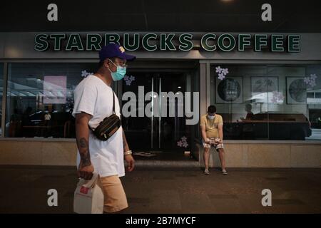 Philippinen. März 2020. Am Montag, 16. März 2020, passieren die Menschen vor einem geschlossenen Starbucks Shop in Mandaluyong City. Starbucks Philippinen kündigte am Dienstag, 17. März 2020 die Schließung ihrer Filialen in Luzon an, während die Geschäfte in Visayas und Mindano-Regionen weiterhin geöffnet bleiben werden. Präsident Rodrigo Duterte kündigte am Montagabend eine erweiterte Gemeinschaftsquarantäne im gesamten Luzon an. Dazu gehören die strikte Quarantäne im Haus, die Einstellung des öffentlichen Personennahverkehrs ab dem 17. März 2020. (Foto von Larry Monserate Piojo/Sipa USA) Credit: SIPA USA/Alamy Live News Stockfoto