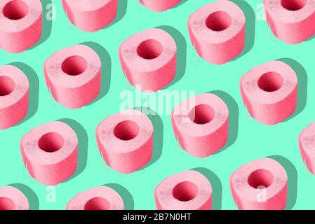 Toilettenpapier auf farbigem Hintergrund. Eine sich wiederholende Rolle aus rosafarbenem Papier. Zeitgenössische Kunst, Minimalismus. Stockfoto