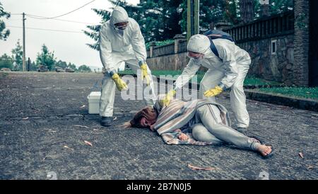 Ärzte im Schutz passen zur Pflege einer Frau Stockfoto