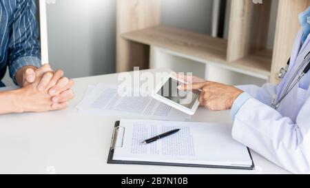 Technologie in Medizin und Gesundheitswesen, Beratung Von Ärzten Diskussion von Aufzeichnungen mit dem Patienten durch Verwendung digitaler Tablette in der Arztpraxis. Stockfoto