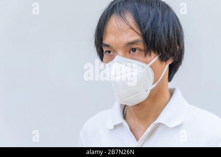 Ein asiatischer Mann trägt N95-Maske zum Schutz von PM2,5-Staub und -Krankheiten Stockfoto