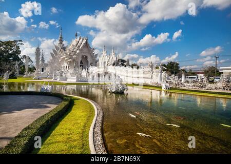 Wat Rong Khun The White Temple und Teich mit Fischen in Chiang Rai, Thailand Stockfoto