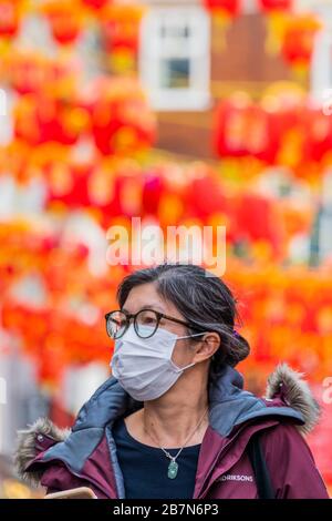 London, Großbritannien. März 2020. Touristen und Einheimische verdecken sich, während sie die ruhigeren Straßen von China Town durchstreifen - Anti Coronavirus (Covid 19)-Verteidigung, die in London unangsam Masken trägt. Credit: Guy Bell/Alamy Live News Stockfoto