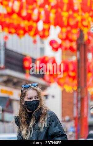London, Großbritannien. März 2020. Touristen und Einheimische verdecken sich, während sie die ruhigeren Straßen von China Town durchstreifen - Anti Coronavirus (Covid 19)-Verteidigung, die in London unangsam Masken trägt. Credit: Guy Bell/Alamy Live News Stockfoto