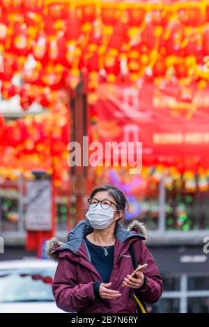 London, Großbritannien. März 2020. Touristen und Einheimische verdecken sich, während sie die ruhigeren Straßen von China Town durchstreifen - Anti Coronavirus (Covid 19)-Verteidigung, die in London unangsam Masken trägt. Credit: Guy Bell/Alamy Live News Stockfoto