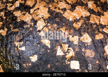 Textur des goldenen Blattes, das auf der Oberfläche der Buddha-Statue geklebt ist Stockfoto