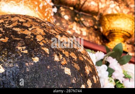 Textur des goldenen Blattes, das auf der Oberfläche der Buddha-Statue geklebt ist Stockfoto