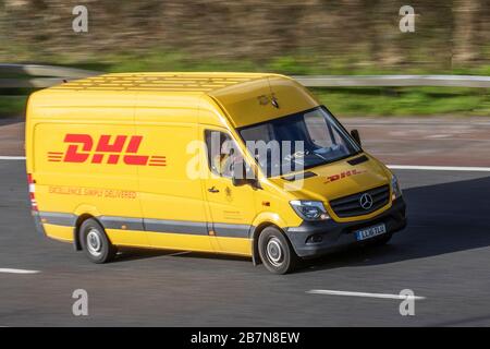 DHL-Liefermann, der einen gelben Mercedes Sprinter van M6 fährt, Lancaster, Großbritannien; kommerzieller Business Transport, moderner Kurier, Paketzustellfahrzeug und Expresspostfahrzeug, Richtung Norden auf der 3-spurigen Autobahn. Stockfoto